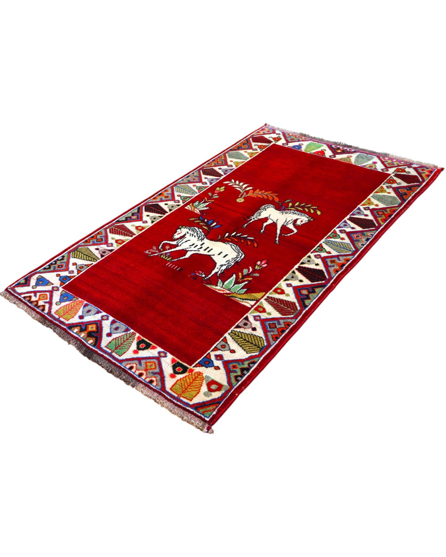 Tappeto Gashgai 185x111 cm annodato a mano, con cavalli stilizzati bianchi su fondo rosso e cornice geometrica multicolore.
