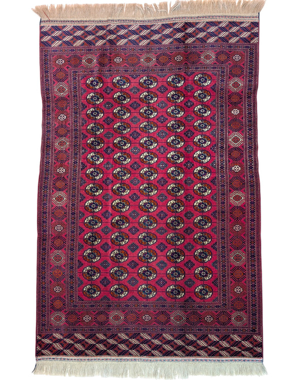 Tappeto Bukhara 278x180 cm con fondo rosso e motivi a gul in nero e avorio, tramato ed annodato a mano, provenienza Asia Centrale.