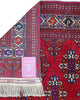 Tappeto Bukhara 280x180 cm con fondo rosso rubino e motivi geometrici ripetuti, tramato ed annodato a mano, provenienza Asia Centrale.