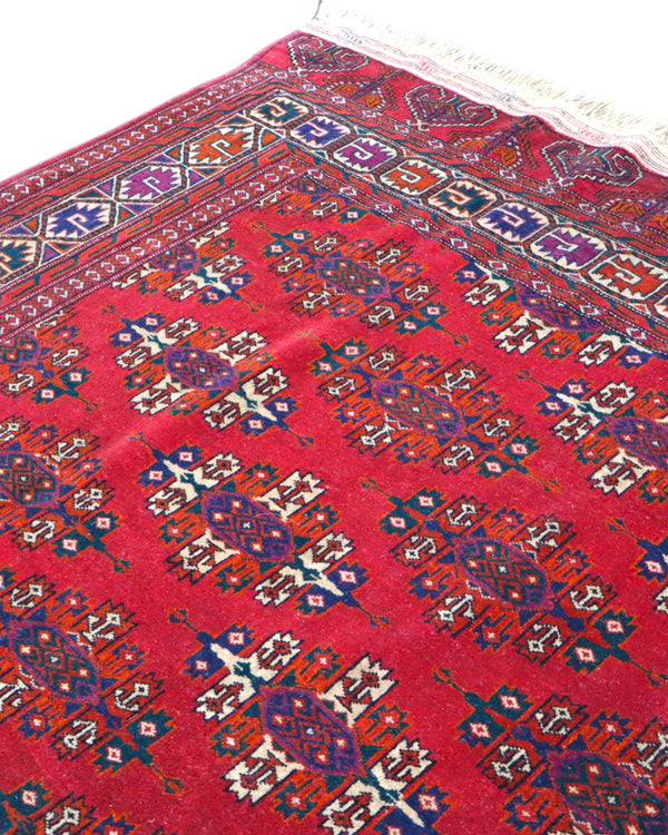 Tappeto Bukhara 280x180 cm con fondo rosso rubino e motivi geometrici ripetuti, tramato ed annodato a mano, provenienza Asia Centrale.