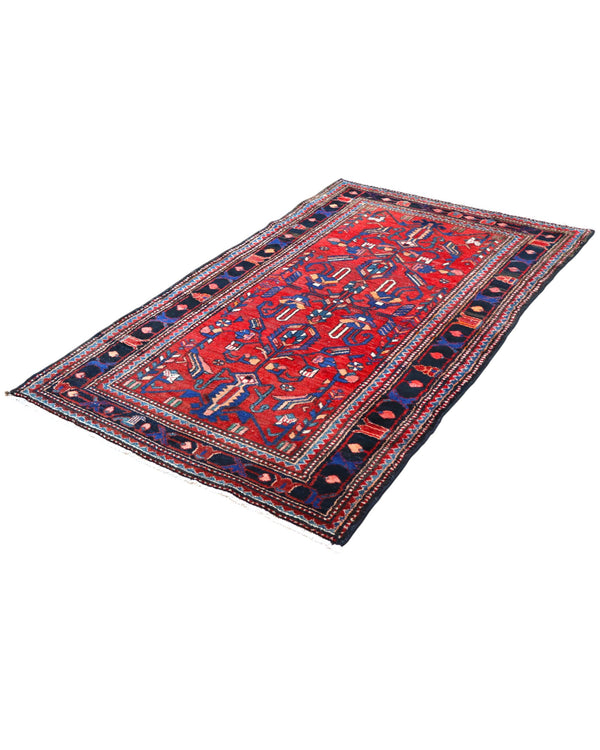 Tappeto Hamedan 200x130 cm persiano, rettangolare, annodato a mano, fondo rosso con motivi geometrici e floreali blu e avorio, bordi decorati.