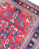 Tappeto Hamedan 200x130 cm persiano, rettangolare, annodato a mano, fondo rosso con motivi geometrici e floreali blu e avorio, bordi decorati.
