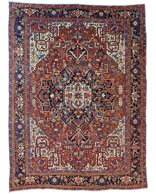 Tappeto Heriz persiano 336x248 cm, annodato a mano in lana e cotone, con medaglione geometrico e motivi floreali tradizionali.