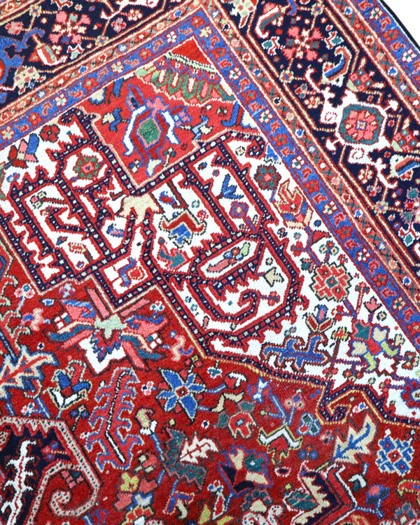 Tappeto Heriz persiano 336x248 cm, annodato a mano in lana e cotone, con medaglione geometrico e motivi floreali tradizionali.