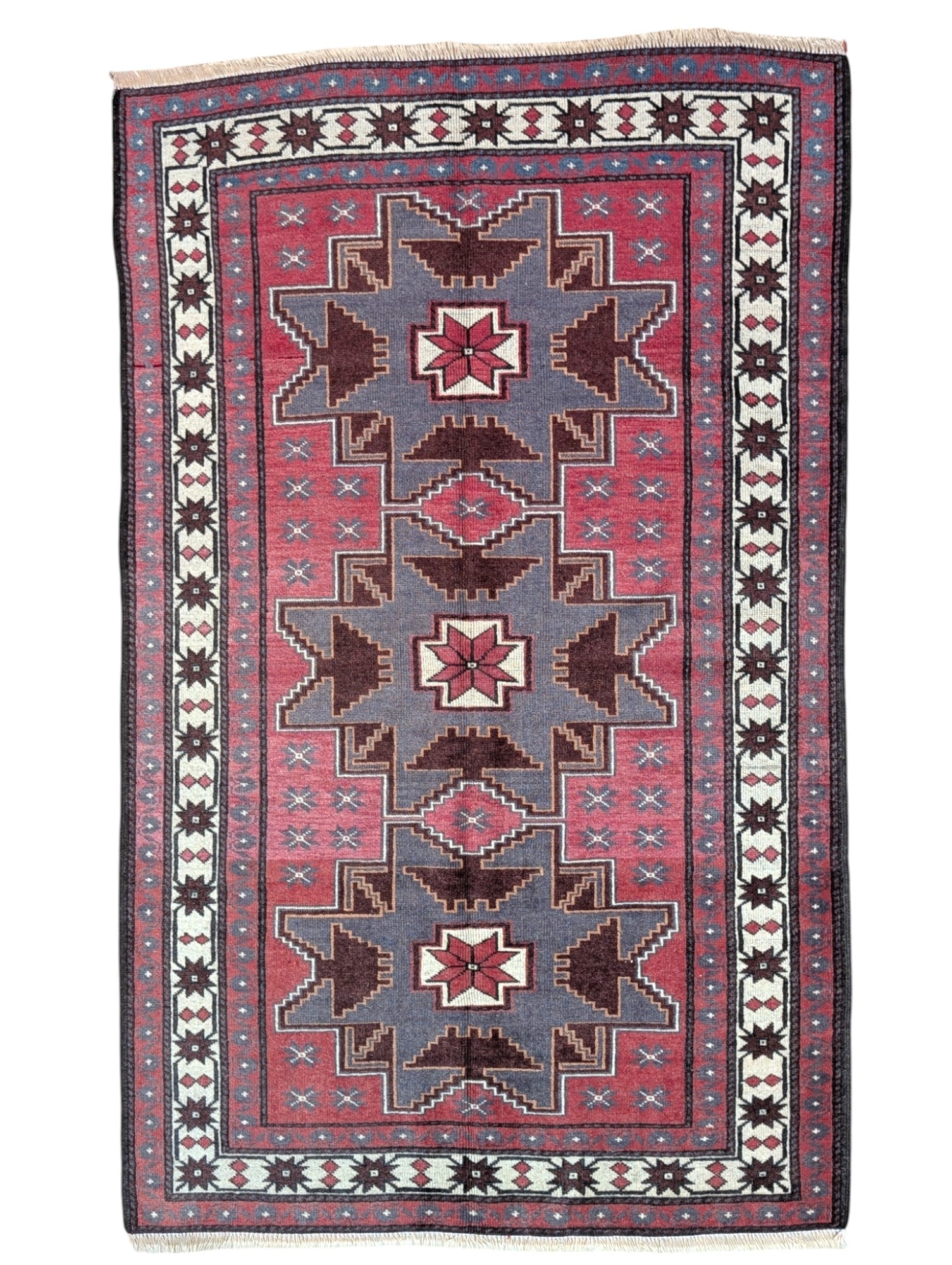 Tappeto Kazak 181x113 cm con motivo geometrico a stelle in rosso, blu e beige, annodato a mano con lana pregiata e ordito in cotone robusto.