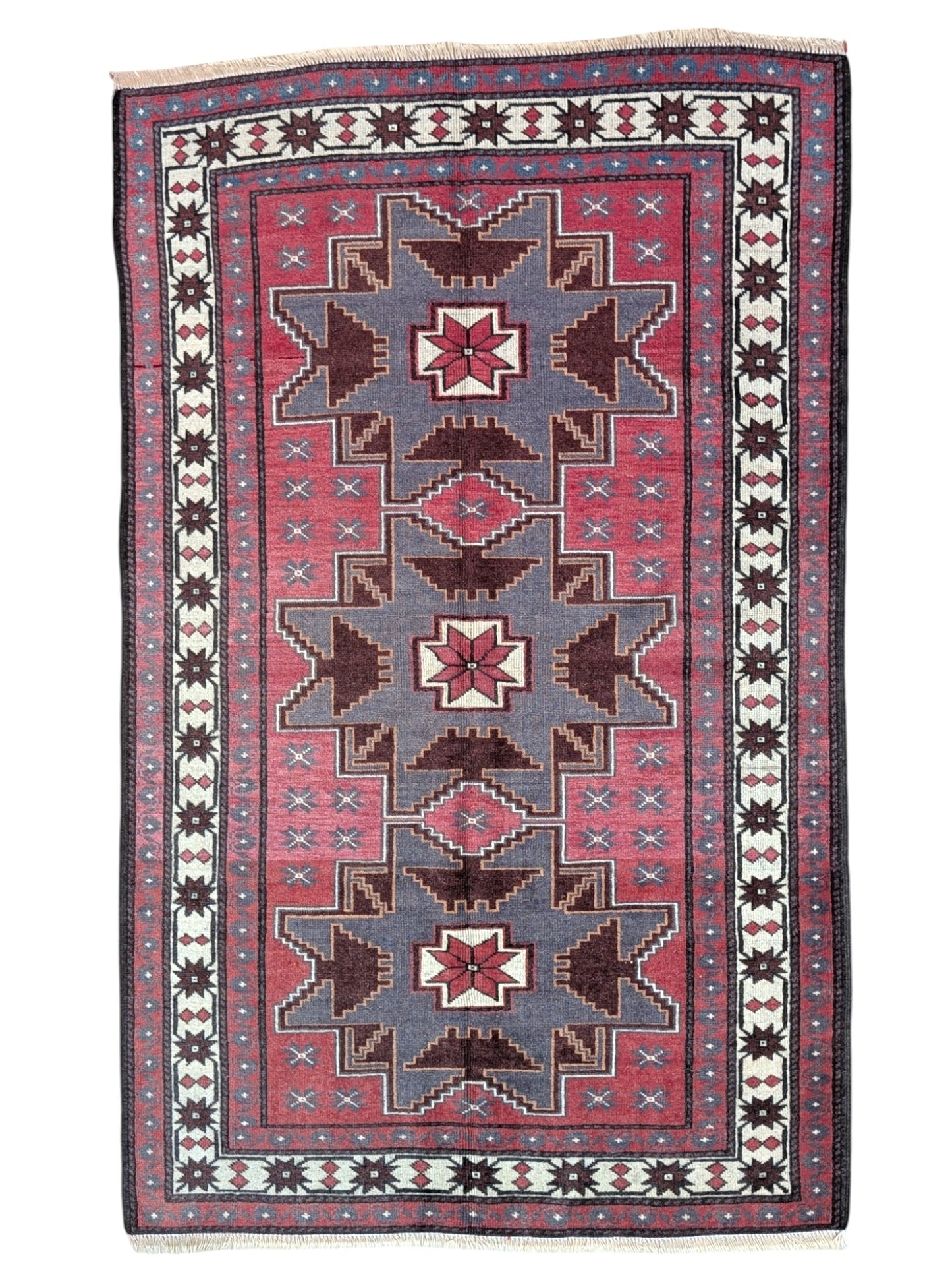 Tappeto Kazak 181x113 cm con motivo geometrico a stelle in rosso, blu e beige, annodato a mano con lana pregiata e ordito in cotone robusto.