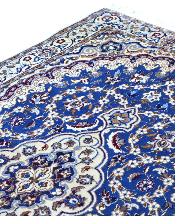 Tappeto Nain 208x120 cm persiano, annodato a mano, fondo blu con medaglione centrale avorio e motivi floreali in lana e seta.
