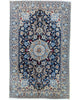 Tappeto Nain 9 fili 191x120 cm annodato a mano, rettangolare, in lana e cotone con colori vegetali, design floreale persiano su fondo blu scuro.
