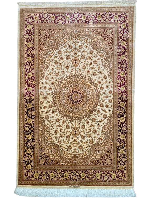 Tappeto Qum in pura seta 155x100 cm, annodato a mano in Persia, fondo oro con motivi decorativi raffinati, seta tinta vegetale, certificato incluso.