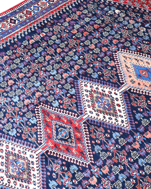 Tappeto Yalame persiano 346x265 cm, annodato a mano in lana e cotone, fondo blu con disegni geometrici tradizionali.