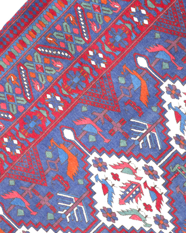 Tappeto afgano 289x196 cm con fondo blu e motivi geometrici avorio e rossi, tramato ed annodato a mano, provenienza Afghanistan.