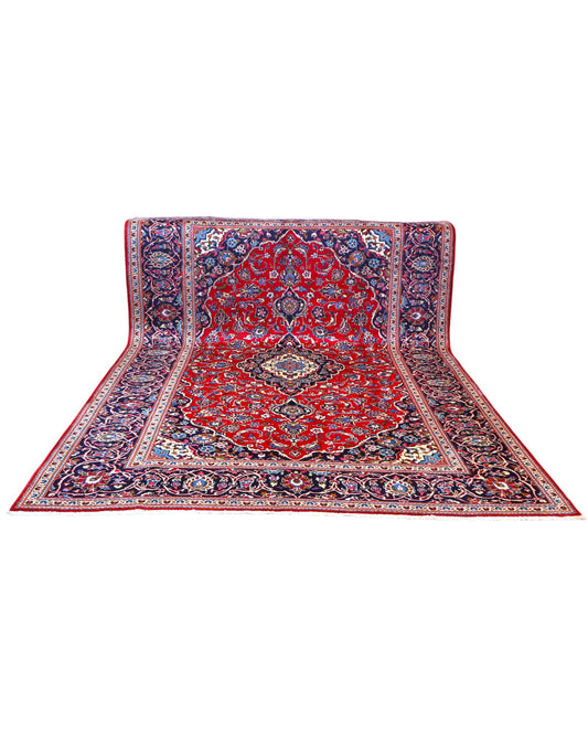 Tappeto persiano Kashan 370x250 cm, fondo rosso con medaglione centrale e cornice blu floreale, annodato a mano in lana vegetale.