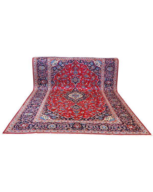 Tappeto persiano Kashan 370x250 cm, fondo rosso con medaglione centrale e cornice blu floreale, annodato a mano in lana vegetale.