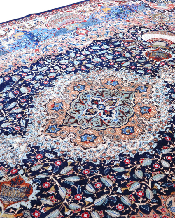 Tappeto persiano Kashmar 384x293 cm, fondo blu con medaglione centrale e motivi floreali e figurativi, annodato a mano in lana vegetale.