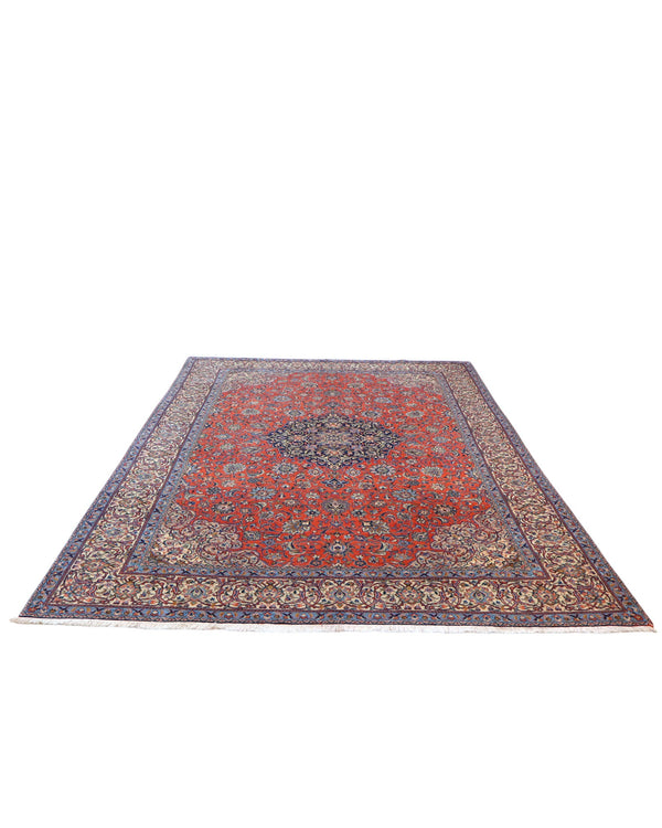 Tappeto persiano Saurk 345x240 cm, fondo rosso corallo con medaglione blu e cornice floreale chiara, annodato a mano in lana vegetale.