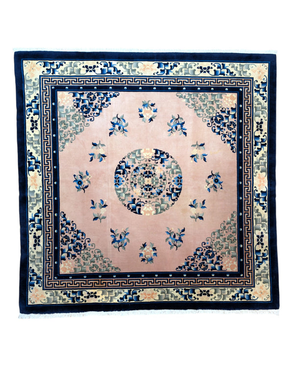 Tappeto Pechino con medaglione centrale, angoli floreali stilizzati, e bordura a greca, color buccia di cipolla e blu, realizzato con lana Merinos e cotone resistente.