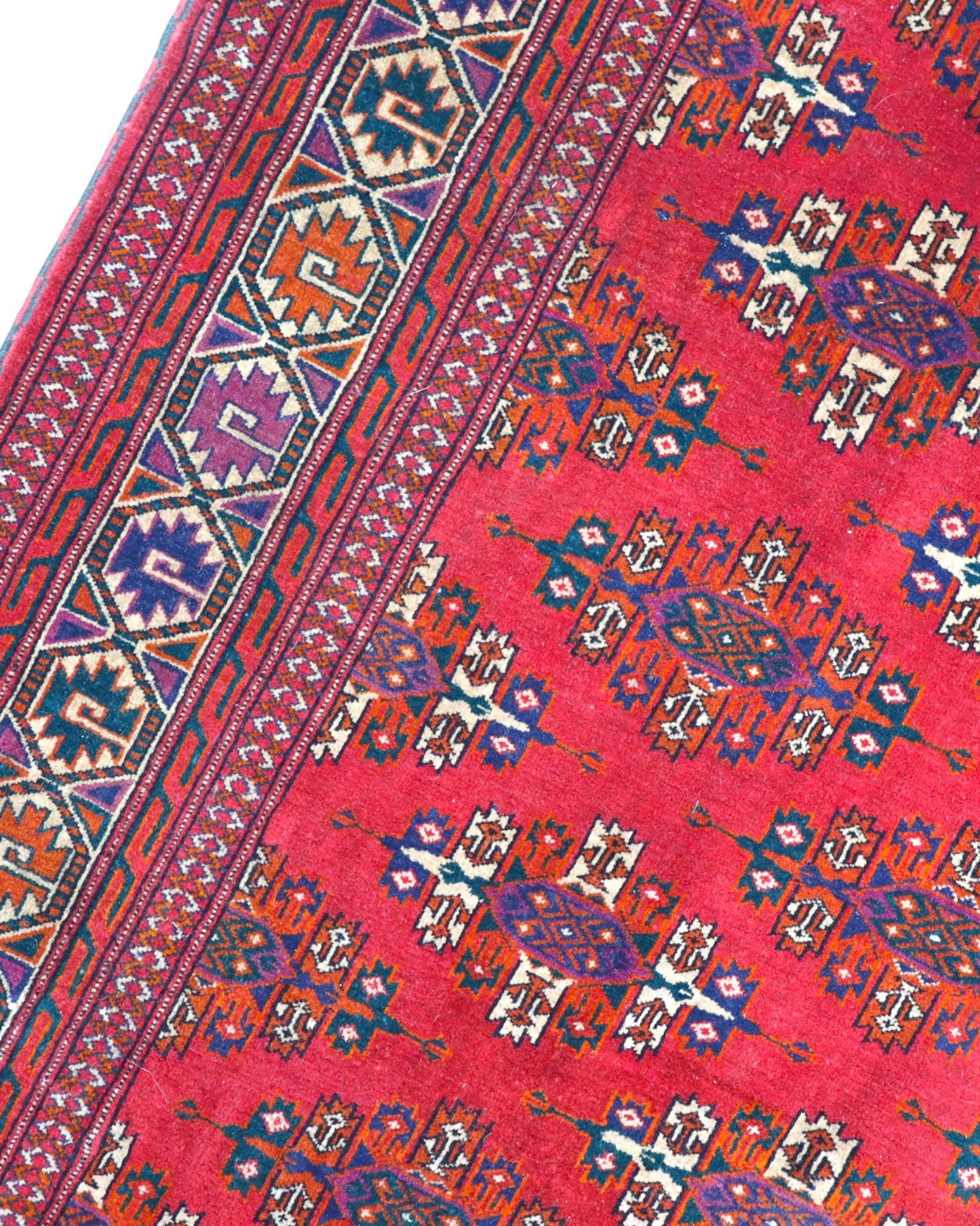 Tappeto Bukhara 280x180 cm con fondo rosso rubino e motivi geometrici ripetuti, tramato ed annodato a mano, provenienza Asia Centrale.