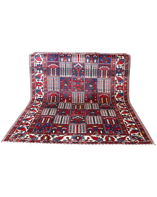 Tappeto persiano Bakhtiar 306x211 cm, motivo a pannelli con decorazioni floreali e geometriche in rosso, blu e avorio, annodato a mano in lana vegetale.