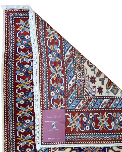 Elegante tappeto Shirvan annodato a mano in pura lana con colori vegetali. Dimensioni 301x83 cm, fondo beige con cornice rossa e motivi geometrici tradizionali afgani. Ideale per corridoi e ambienti raffinati.