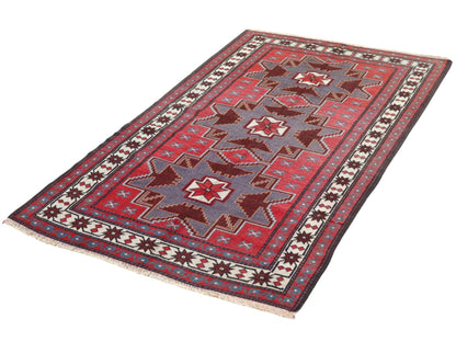 Tappeto Kazak 181x113 cm con motivo geometrico a stelle in rosso, blu e beige, annodato a mano con lana pregiata e ordito in cotone robusto.
