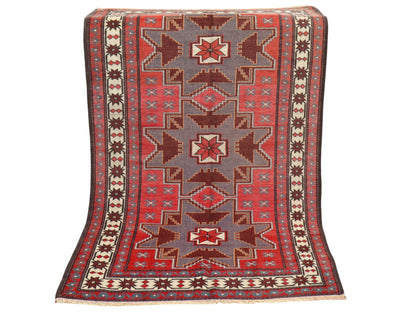 Tappeto Kazak 181x113 cm con motivo geometrico a stelle in rosso, blu e beige, annodato a mano con lana pregiata e ordito in cotone robusto.