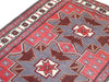 Tappeto Kazak 181x113 cm con motivo geometrico a stelle in rosso, blu e beige, annodato a mano con lana pregiata e ordito in cotone robusto.