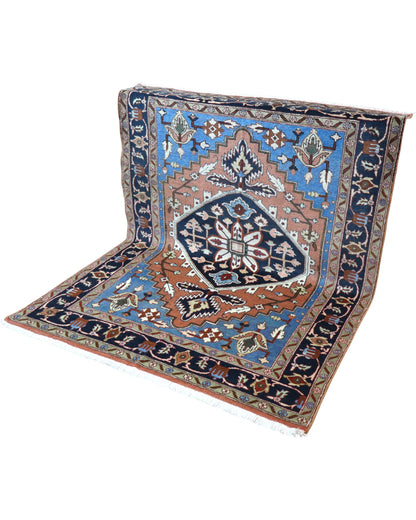 Tappeto Heriz "Giardino Persiano" fondo celeste con motivi geometrici e floreali, annodato a mano in Persia.