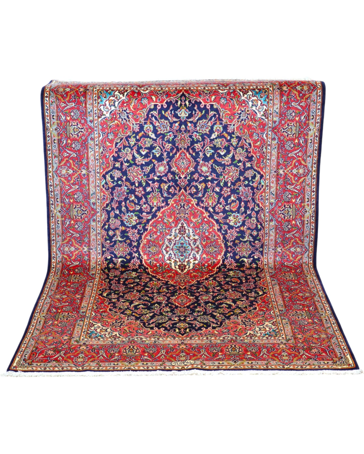 Tappeto Kashan persiano 225x142 cm, annodato a mano, fondo blu notte con motivo floreale e cornice rossa decorata, lana mista seta, certificato di autenticità incluso.