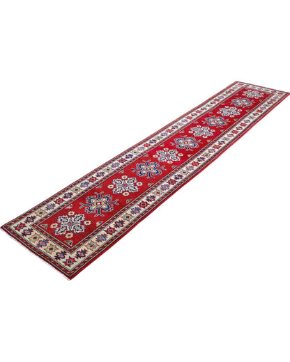 Passatoia Kazak annodata a mano (297x61 cm) in lana, con sfondo rosso melograno e bordo beige, con motivi geometrici afgani.

