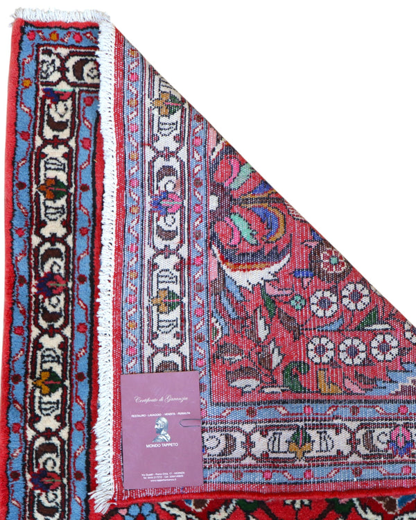 Passatoia persiana Lilian 297x78 cm annodata a mano in lana con colori vegetali, caratterizzata da un elegante fondo rosso antico e motivi decorativi.

