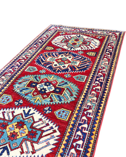 Passatoia Kazak afgana 351x91 cm annodata a mano in lana, con un design audace caratterizzato da motivi geometrici su un fondo rosso intenso.
