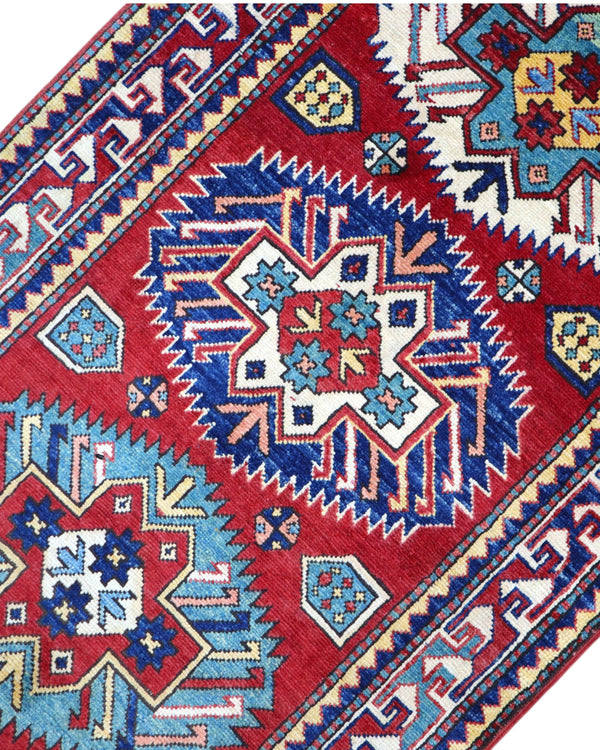 Passatoia Kazak afgana 351x91 cm annodata a mano in lana, con un design audace caratterizzato da motivi geometrici su un fondo rosso intenso.