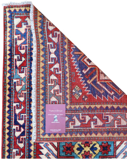 Passatoia Kazak afgana 351x91 cm annodata a mano in lana, con un design audace caratterizzato da motivi geometrici su un fondo rosso intenso.