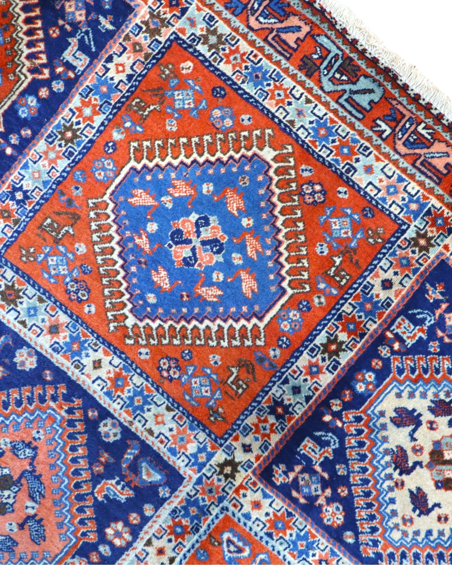 Tappeto Yalamhe persiano, fondo rosso mattone con motivi geometrici in blu, annodato a mano, 232x157 cm.
