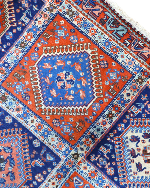 Tappeto Yalamhe persiano, fondo rosso mattone con motivi geometrici in blu, annodato a mano, 232x157 cm.