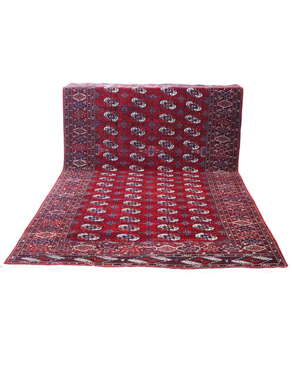 Tappeto Bukhara 324x205 cm con fondo rosso scuro e motivi a gul geometrici in nero, avorio e blu, tramato ed annodato a mano, provenienza Bukhara.