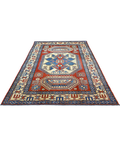 Tappeto Kazak 246x210 cm con fondo avorio e rosso, medaglione geometrico blu e motivi stilizzati, tramato ed annodato a mano, provenienza Caucaso.
