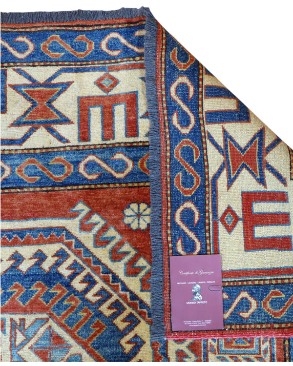 Tappeto Kazak 246x210 cm con fondo avorio e rosso, medaglione geometrico blu e motivi stilizzati, tramato ed annodato a mano, provenienza Caucaso.