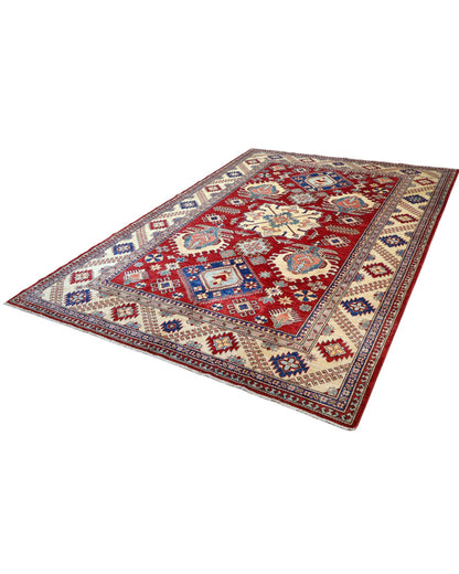 Tappeto Kazak 330x224 cm con fondo rosso, medaglione centrale avorio e motivi geometrici blu e azzurri, tramato ed annodato a mano, provenienza Caucaso.