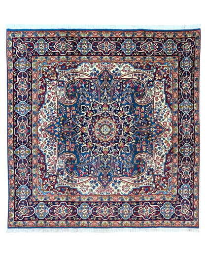 Tappeto Kirman 200x200 cm con motivo floreale centrale in blu, rosso e oro, bordura decorata, annodato a mano con lana pregiata e ordito in cotone.