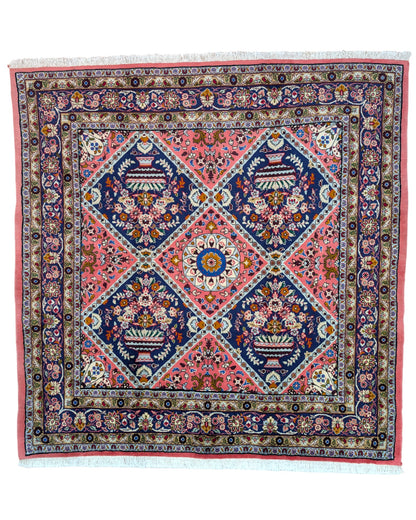 Tappeto Lilian con campo rosso mattone e motivi floreali stilizzati blu, annodato a mano in Persia con cotone e lana vegetale.