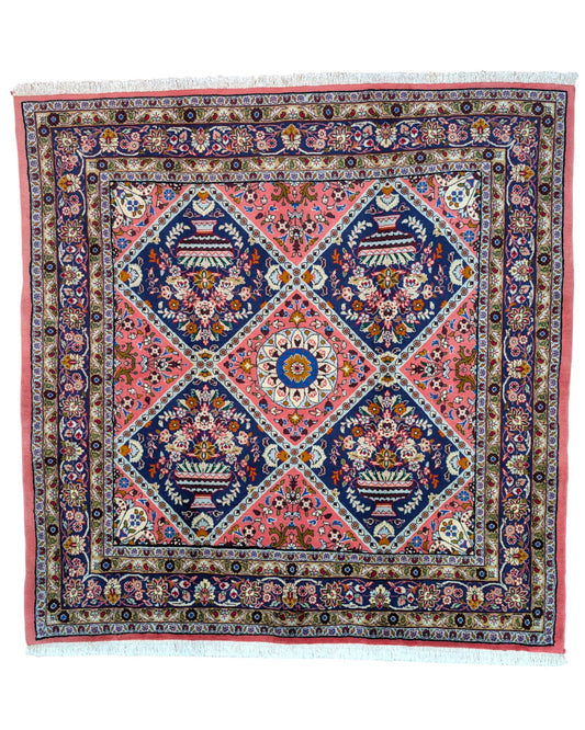 Tappeto Lilian con campo rosso mattone e motivi floreali stilizzati blu, annodato a mano in Persia con cotone e lana vegetale.