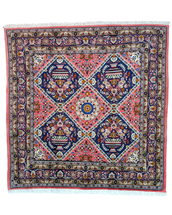 Tappeto Lilian con campo rosso mattone e motivi floreali stilizzati blu, annodato a mano in Persia con cotone e lana vegetale.