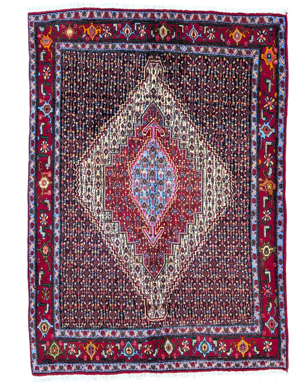 Tappeto Senneh persiano beige e rosso, annodato a mano in lana e cotone con medaglione geometrico e colori vegetali naturali.