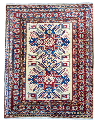 Tappeto Shirvan beige con motivi geometrici multicolori, annodato a mano in Afghanistan. Realizzato in pura lana con colori vegetali, unisce arte tradizionale e design autentico.