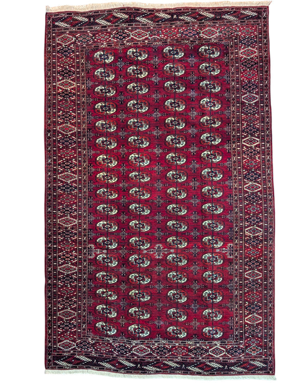 Tappeto Bukhara 324x205 cm con fondo rosso scuro e motivi a gul geometrici in nero, avorio e blu, tramato ed annodato a mano, provenienza Bukhara.