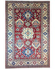 Tappeto Kazak 330x224 cm con fondo rosso, medaglione centrale avorio e motivi geometrici blu e azzurri, tramato ed annodato a mano, provenienza Caucaso.