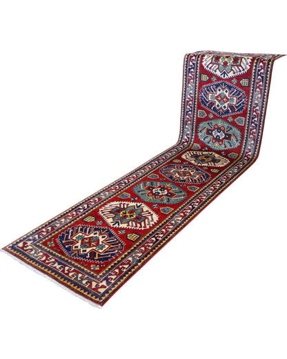 Passatoia Kazak afgana 351x91 cm annodata a mano in lana, con un design audace caratterizzato da motivi geometrici su un fondo rosso intenso.