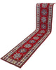 Passatoia Kazak annodata a mano (297x61 cm) in lana, con sfondo rosso melograno e bordo beige, con motivi geometrici afgani.

