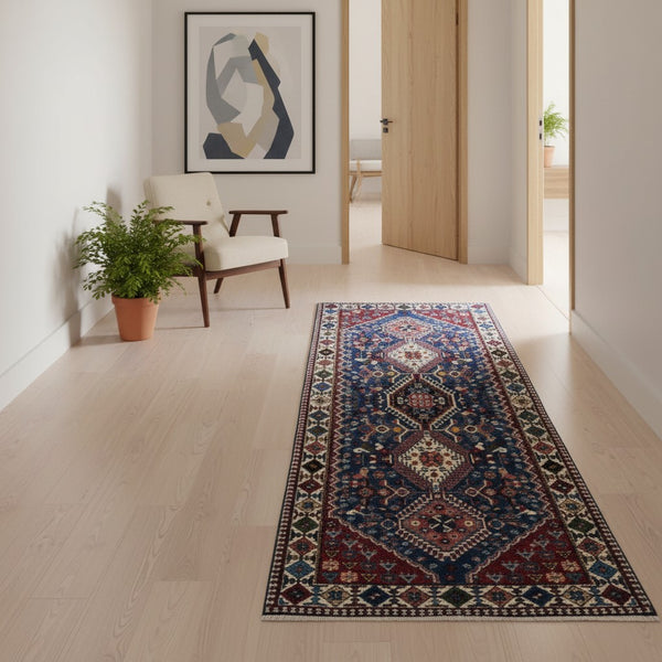 Tappeto persiano Yalameh 204x82 cm, corridore con fondo blu intenso e motivi geometrici rossi, avorio e verdi, annodato a mano in lana vegetale.